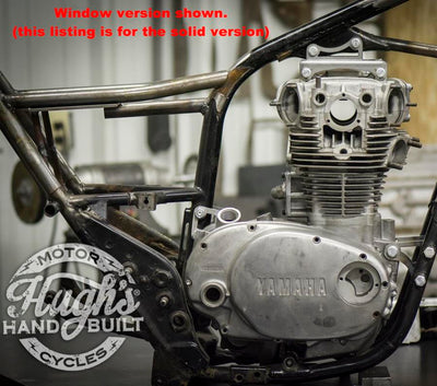 A picture of a motorcycle in a garage featuring the Hughs HandBuilt XS650 Top Motor Mount Solid Fits 1974-83 by Hughs Handbuilt.