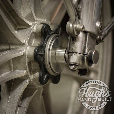A close up of a motorcycle wheel with a brake caliper for Hughs HandBuilt Yamaha XS650 Speedometer Eliminator (fits 1975-1983).