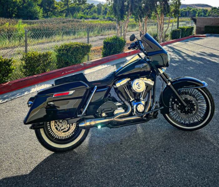 A motorcycle exhaust pipe with an American flag and a SP Concepts Lane Splitter Exhaust Twin Cam Touring 95-16 (stainless) on it.