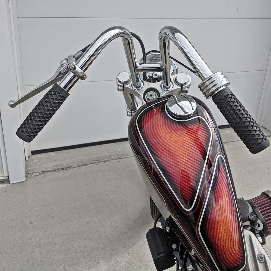 A motorcycle with a Moto Iron® 1" Custom Clutch Lever Assembly For Harley Models (Sportster, Dyna, FX, FL) and handlebars.