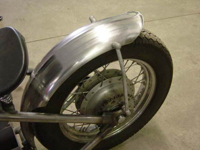 A close up of a motorcycle with a chrome rim and a TC Bros. Universal Chopper/Bobber Fender Mounting Strut Kit.