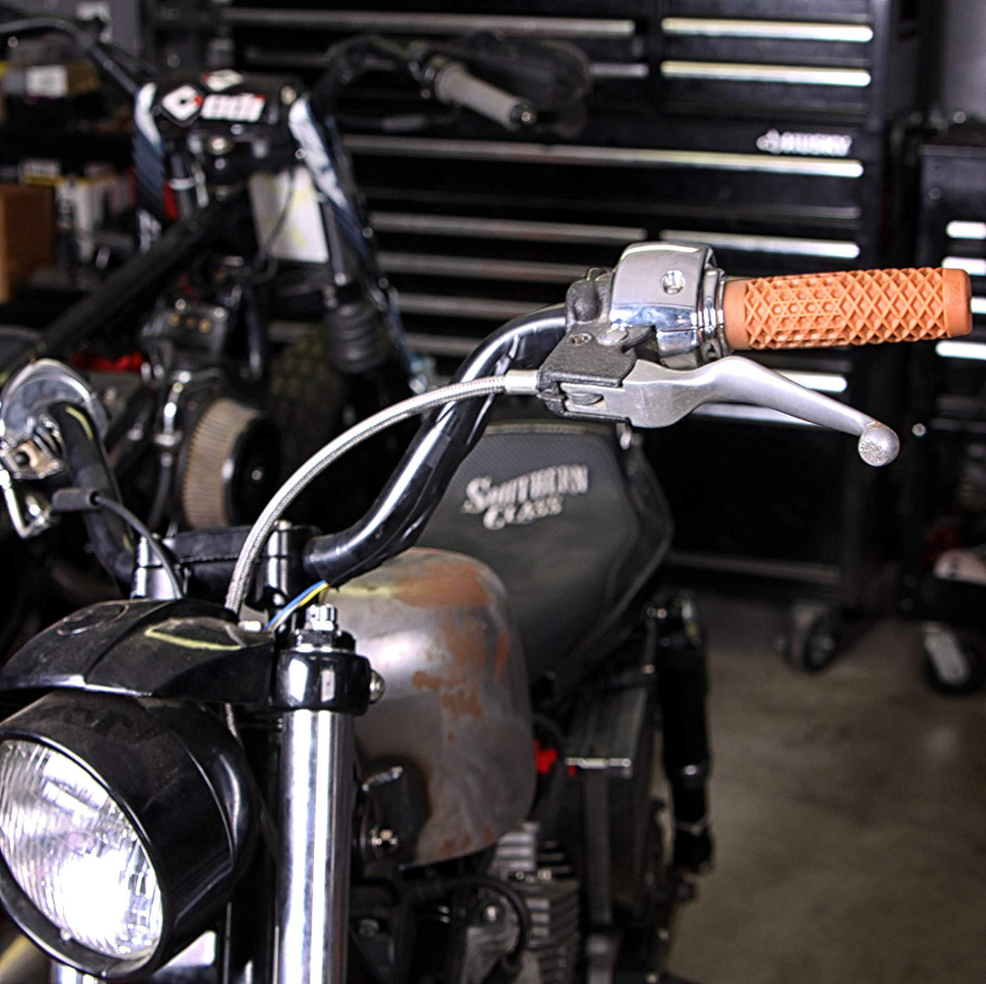 An ODI Vans + Cult Motorcycle Grips - 7/8" Gum Rubber parked in a garage.