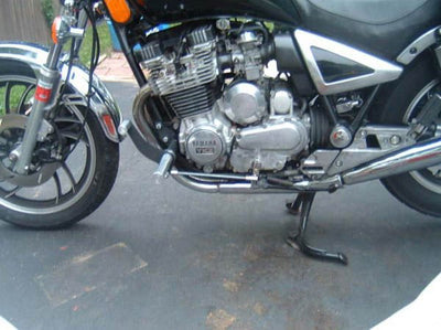 A silver TC Bros. Yamaha Maxim XJ750 Forward Controls Kit motorcycle parked in a driveway.