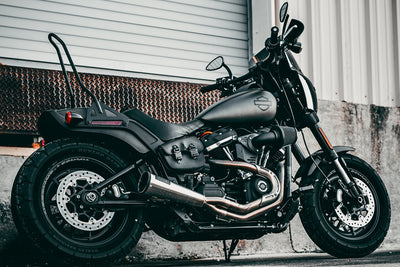 A black motorcycle parked in front of a garage.