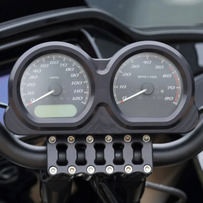 Placed side by side, two billet aluminum components from the TC Bros. Pro Series Gauge Relocation Bezel for Harley Davidson Road Glide feature circular cutouts; one boasts a dark color while the other has a shiny, reflective finish. These bezels from TC Bros. exemplify both style and precision.