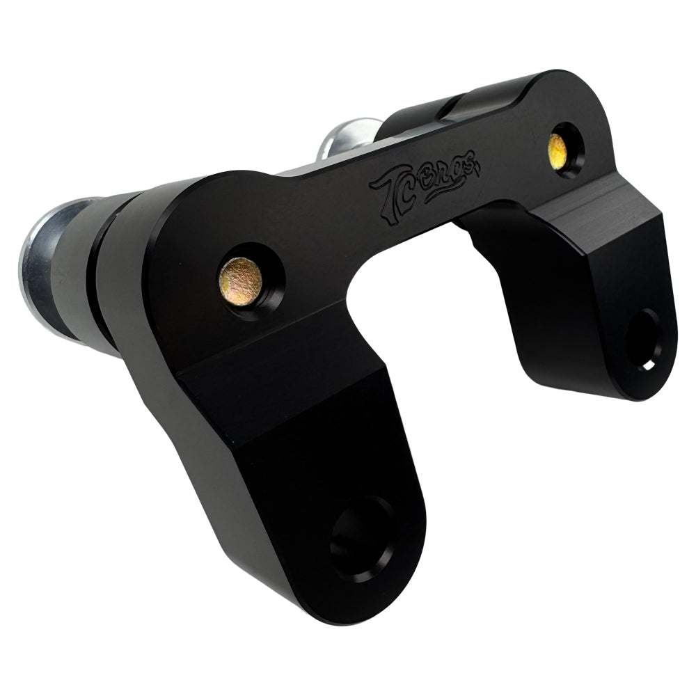 The TC Bros. Pro Series Riser Adapter features black anodized metal, two mounting holes, silver cylindrical ends, and engraved branding—ideal for upgrading 2006-2013 Harley-Davidson Street Glide handlebars.
