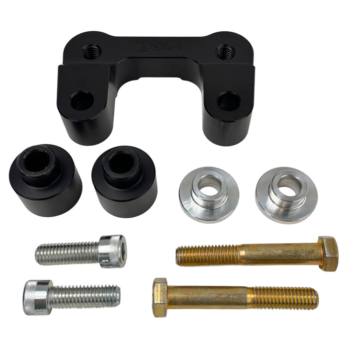 The TC Bros. Pro Series Riser Adapter features black anodized metal, two mounting holes, silver cylindrical ends, and engraved branding—ideal for upgrading 2006-2013 Harley-Davidson Street Glide handlebars.