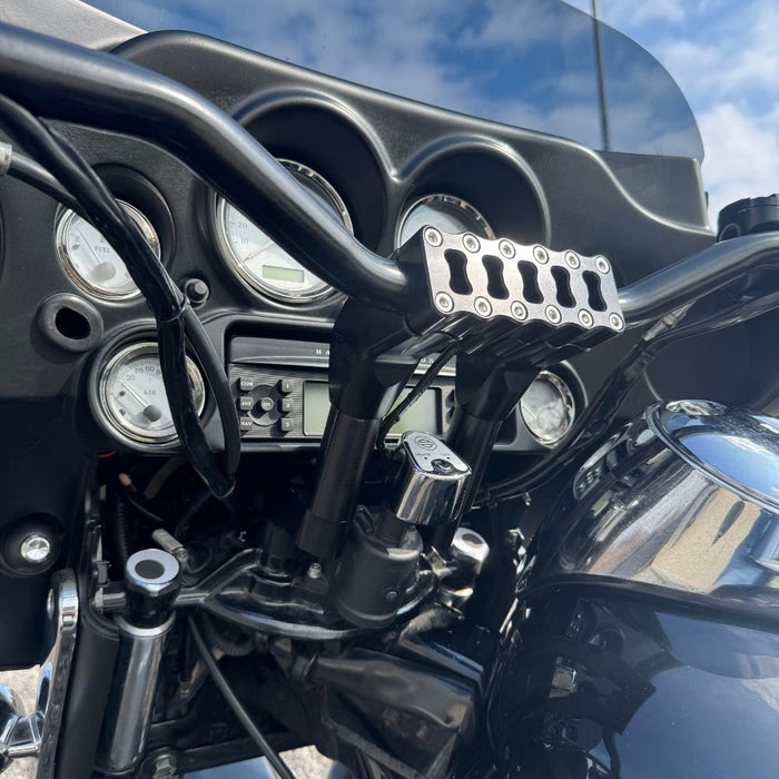 The TC Bros. Pro Series Riser Adapter features black anodized metal, two mounting holes, silver cylindrical ends, and engraved branding—ideal for upgrading 2006-2013 Harley-Davidson Street Glide handlebars.