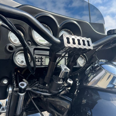 The TC Bros. Pro Series Riser Adapter features black anodized metal, two mounting holes, silver cylindrical ends, and engraved branding—ideal for upgrading 2006-2013 Harley-Davidson Street Glide handlebars.