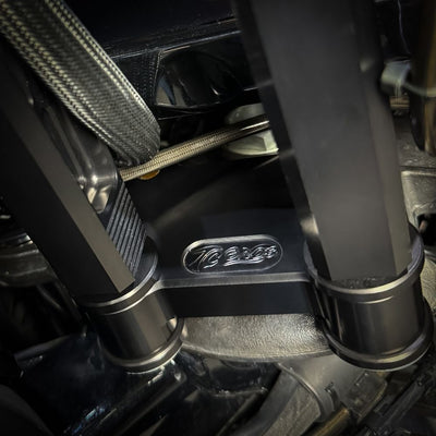 The TC Bros. Pro Series Riser Adapter for 2006-2023 Harley Davidson Street Glide features a black metal bracket with two threaded holes, silver washers, and gold bolts—shown on a white background. Perfect for performance upgrades.