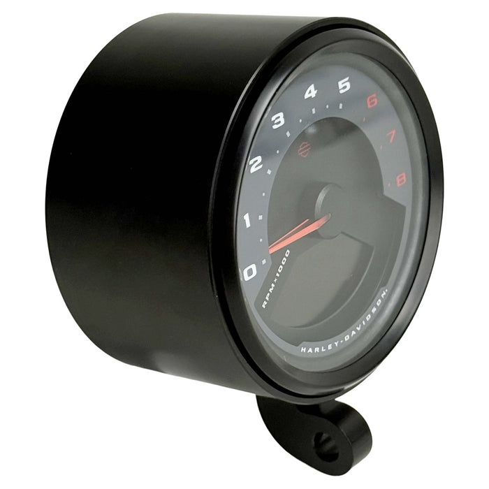 Two cylindrical motorcycle tachometer bezels from TC Bros., including the Pro Series 4 inch Gauge Relocation Bezel for Harley Davidson, in black and silver finishes with similar gauge faces featuring numbers and a red needle.