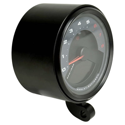 Two cylindrical motorcycle tachometer bezels from TC Bros., including the Pro Series 4 inch Gauge Relocation Bezel for Harley Davidson, in black and silver finishes with similar gauge faces featuring numbers and a red needle.