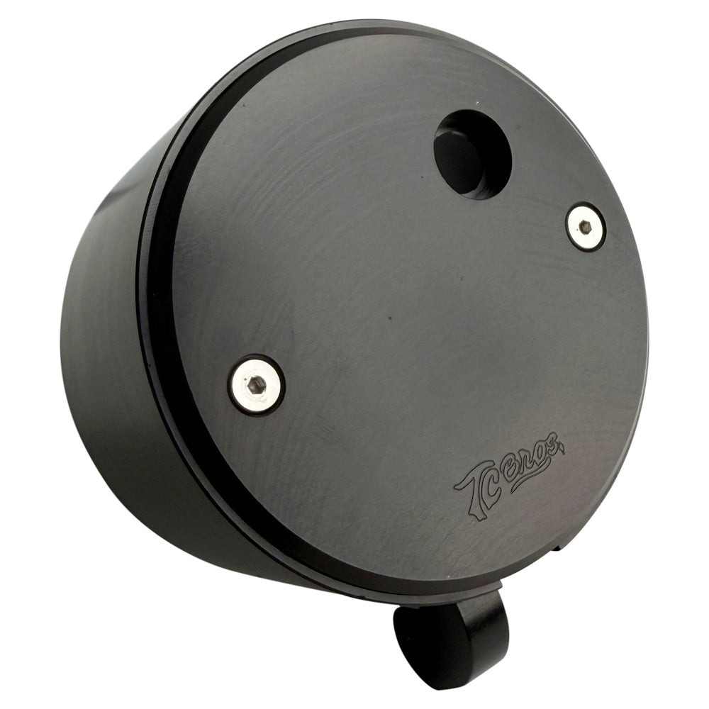 Two cylindrical motorcycle tachometer bezels from TC Bros., including the Pro Series 4 inch Gauge Relocation Bezel for Harley Davidson, in black and silver finishes with similar gauge faces featuring numbers and a red needle.