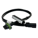 The Guerrilla Cables Speedometer Relocation Harness for 2014-2022 Harley-Davidson Sportster (Single Gauge) is a black electrical cable featuring a rectangular connector on one end and a multi-pin connector on the other, coiled into a loose loop—designed by Guerrilla Cables as a plug-and-play solution for relocating your Sportster’s speedometer.