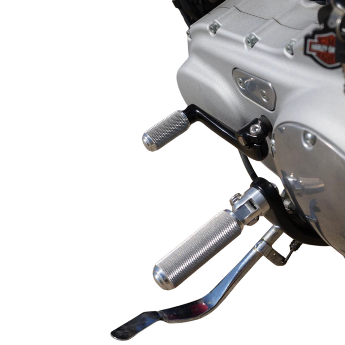 The TC Bros. Nomad Shift/Brake Peg for Harley-Davidson features CNC-machined aluminum pegs in silver, gold, and black with textured grips and threaded bolts. Ideal as a shift or brake peg. "NOMAD SHIFT/TOE PEG" text appears at the top.