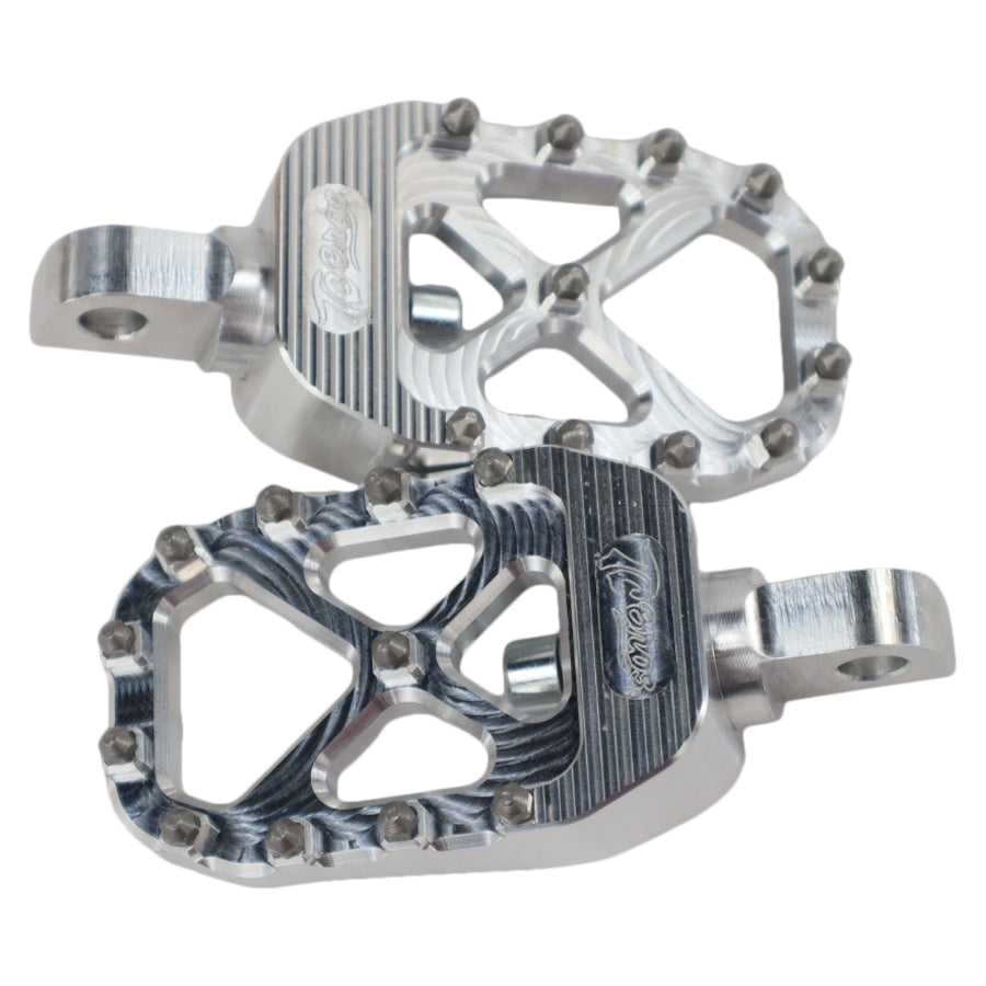 The TC Bros. Pro Series MX Foot Pegs for Harley Davidson come in silver, black, and gold with a rugged, spiked design and diagonal layout for superior grip.