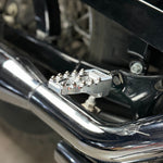 Four TC Bros. Pro Series MX Lite Footpegs for 1977-2022 Harley-Davidson in silver, black, and gold are arranged vertically on a white background.