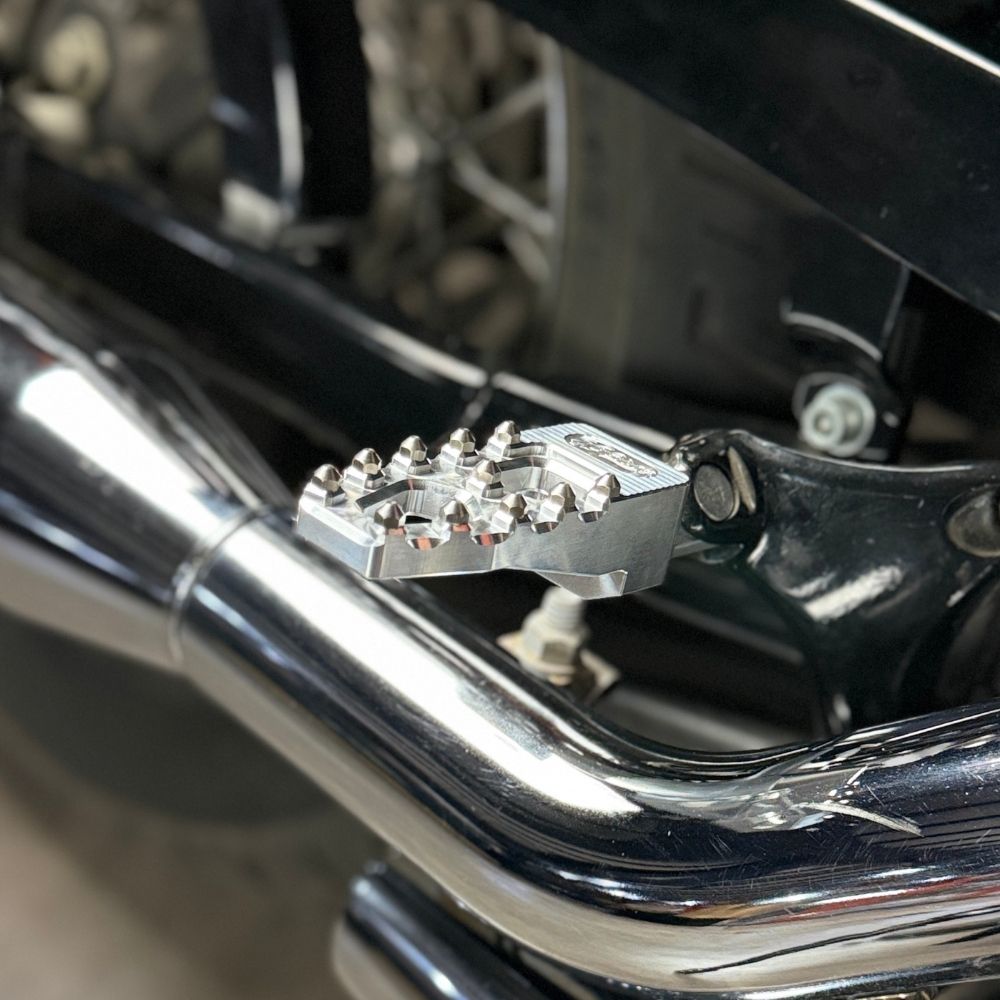 Four TC Bros. Pro Series MX Lite Footpegs for 1977-2022 Harley-Davidson in silver, black, and gold are arranged vertically on a white background.