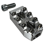 Close-up of a CNC-machined TC Bros. Pro Series MX Shifter/Brake Peg and foot peg assembly, mounted near the engine and exhaust pipes on a concrete surface.
