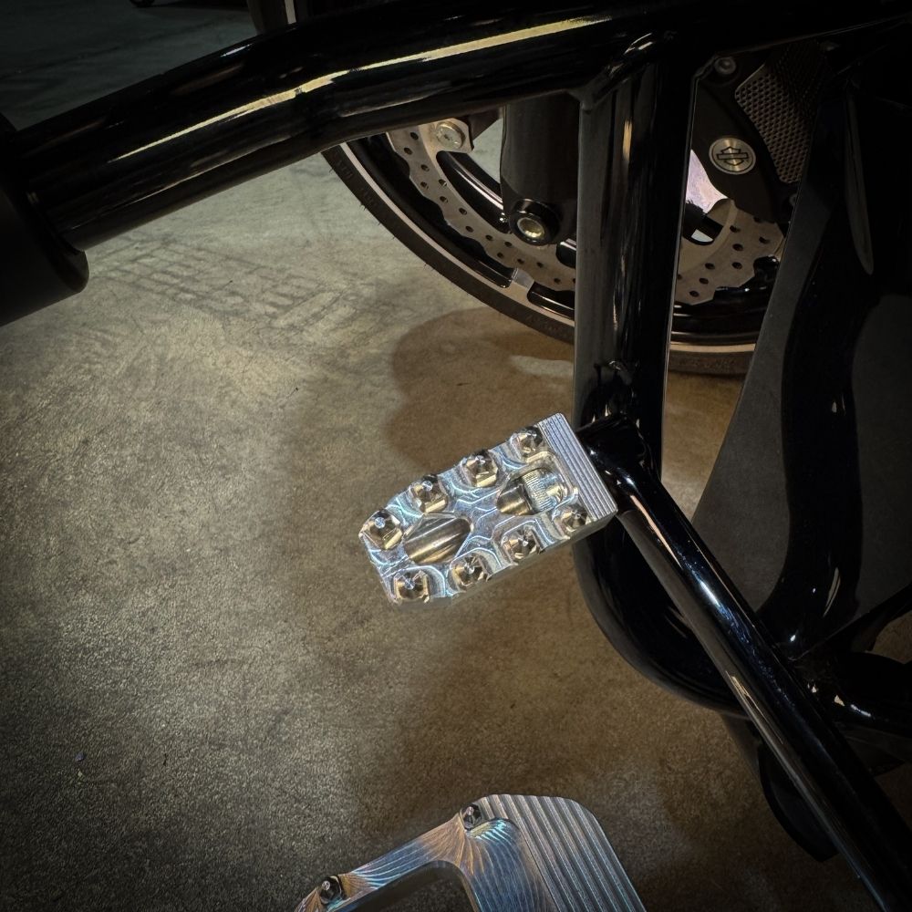 Three TC Bros. Pro Series MX Shifter/Brake Pegs for Harley Davidson, available in silver, black, and gold with multiple spikes, are shown with a metal bolt.