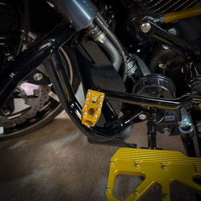 Three TC Bros. Pro Series MX Shifter/Brake Pegs for Harley Davidson, available in silver, black, and gold with multiple spikes, are shown with a metal bolt.