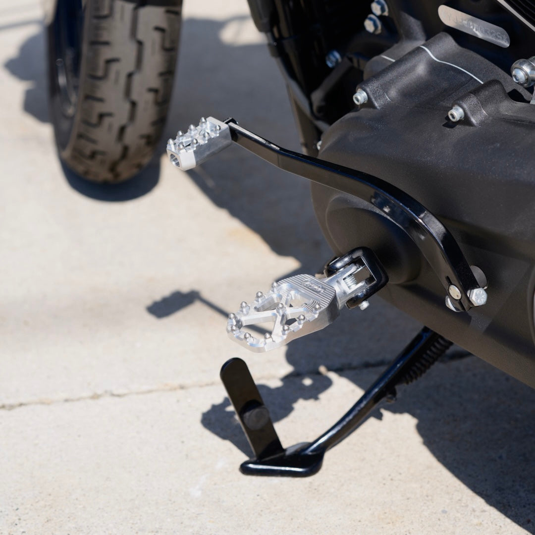 The TC Bros. Pro Series MX Foot Pegs for Harley Davidson come in silver, black, and gold with a rugged, spiked design and diagonal layout for superior grip.