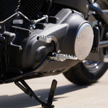 Three TC Bros. Pro Series MX Lite Foot Pegs for Harley Davidson models, featuring metallic spiked surfaces, are arranged side by side in silver, black, and gold.