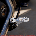 Four TC Bros. Pro Series MX Lite Footpegs for 1977-2022 Harley-Davidson in silver, black, and gold are arranged vertically on a white background.