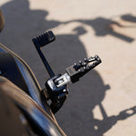 Three TC Bros. Pro Series MX Lite Foot Pegs for Harley Davidson models, featuring metallic spiked surfaces, are arranged side by side in silver, black, and gold.