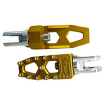 Three TC Bros. Pro Series MX Lite Foot Pegs for Harley Davidson models, featuring metallic spiked surfaces, are arranged side by side in silver, black, and gold.