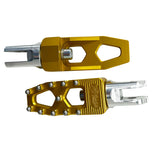 Three TC Bros. Pro Series MX Lite Foot Pegs for Harley Davidson models, featuring metallic spiked surfaces, are arranged side by side in silver, black, and gold.