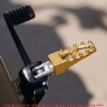 Four TC Bros. Pro Series MX Lite Footpegs for 1977-2022 Harley-Davidson in silver, black, and gold are arranged vertically on a white background.