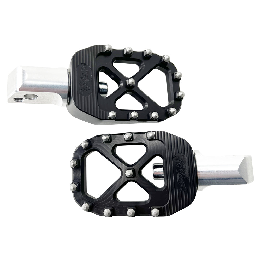 A pair of TC Bros. Pro Series Black MX Passenger Foot Pegs for 2018-newer Harley Softail & Pan America with silver metal pins and an open geometric design. Reminiscent of high traction motorcycle foot pegs, they feature a studded texture for grip and have a silver mounting shaft.