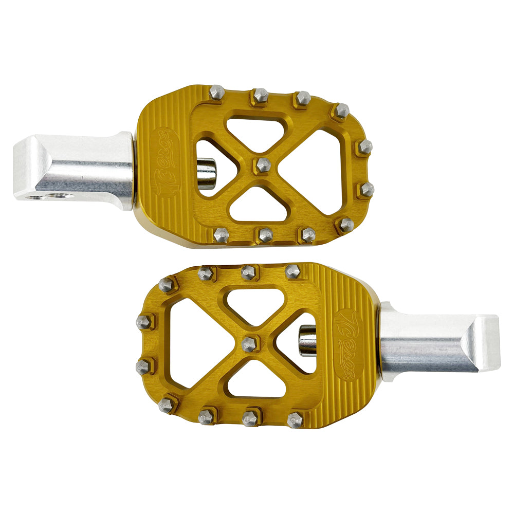 A pair of golden bicycle pedals with a metallic silver base, featuring spiked edges for grip, reminiscent of the rugged design found in TC Bros. Pro Series Gold MX Passenger Foot Pegs for 2018-newer Harley Softail & Pan America by TC Bros.