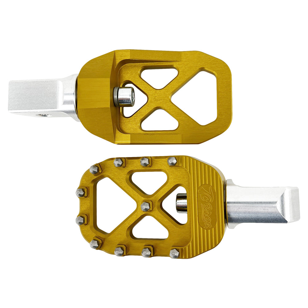 A pair of golden bicycle pedals with a metallic silver base, featuring spiked edges for grip, reminiscent of the rugged design found in TC Bros. Pro Series Gold MX Passenger Foot Pegs for 2018-newer Harley Softail & Pan America by TC Bros.