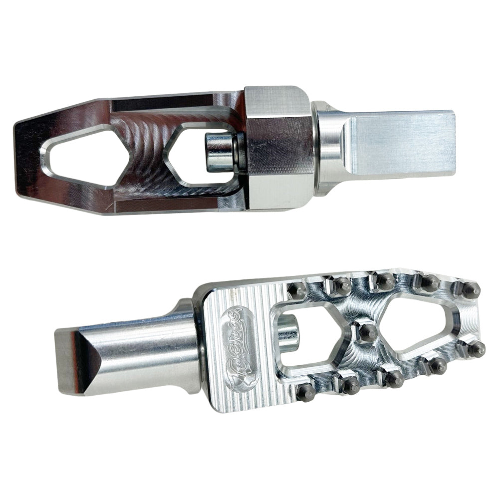 Two silver metal TC Bros. Pro Series MX Lite Passenger Foot Pegs for 2018-newer Harley Softail & Pan America with a durable and rugged design, featuring notched edges for grip and an open frame structure, showcased against a plain background. These high-performance foot pegs are perfect for Harley Softail riders seeking both style and functionality.