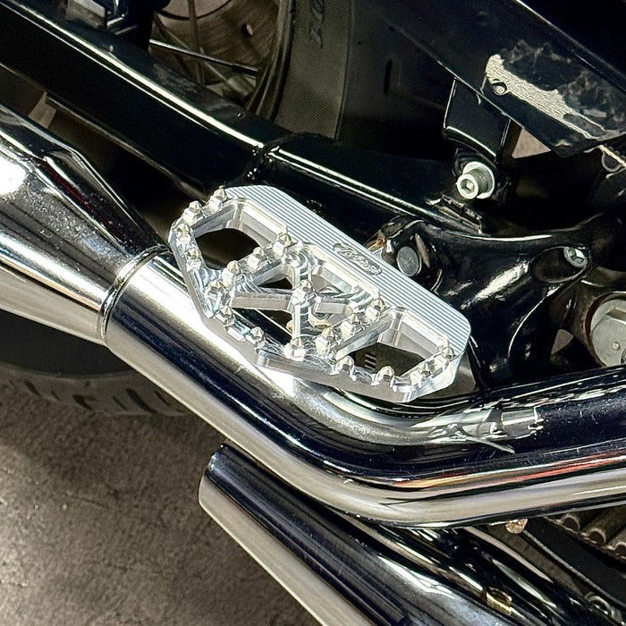 Three TC Bros. Pro Series MX Mini Floorboards for 1977-2022 Harley-Davidson in silver, black, and gold are shown on a white background, each featuring flat metal platforms with grip pins for adjustable foot peg mounting.