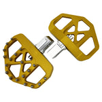 Three TC Bros. Pro Series MX Mini Floorboards for Harley-Davidson, in silver, black, and gold, are diagonally arranged on a white background.