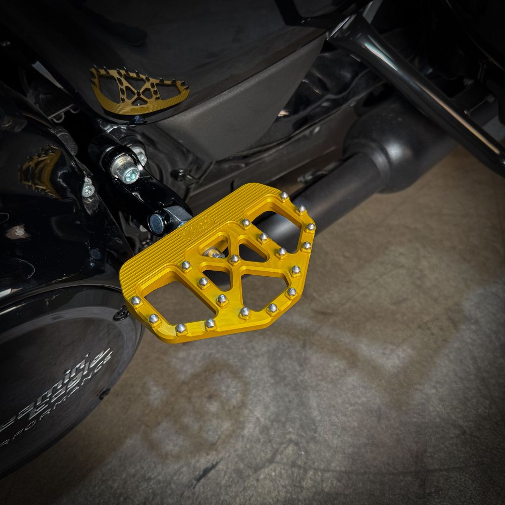 A pair of TC Bros. Pro Series Gold MX Passenger Mini Floorboards for 2018-newer Harley Softail & Pan America, with grip studs, isolated on a white background.