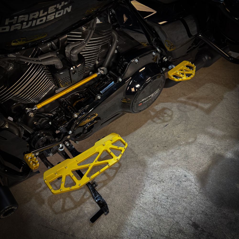 A pair of TC Bros. Pro Series Gold MX Passenger Mini Floorboards for 2018-newer Harley Softail & Pan America, with grip studs, isolated on a white background.