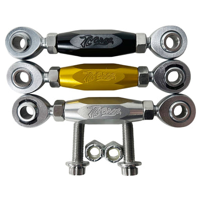 The TC Bros. FXR & M8 Softail Adjustable Shifter Linkage for Mid Controls showcases three adjustable turnbuckle rod ends in black, gold, and silver, arranged vertically. Crafted from CNC machined aluminum, these precision parts are ideal for Harley Davidson shifter linkage applications. Two bolts and two nuts are neatly placed below the rod ends, completing the arrangement.