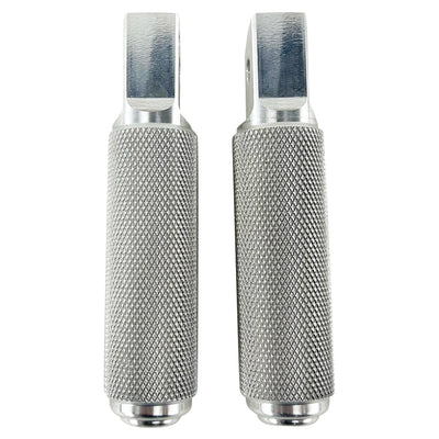 Two stainless steel TC Bros. Nomad Passenger Foot Pegs fits 2018-up Harley Softail M8 & Pan America, one upright and one lying on its side, showcasing their textured grip surfaces and mounting holes—perfect for adding a touch of rugged functionality.