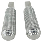 Two stainless steel TC Bros. Nomad Passenger Foot Pegs fits 2018-up Harley Softail M8 & Pan America, one upright and one lying on its side, showcasing their textured grip surfaces and mounting holes—perfect for adding a touch of rugged functionality.