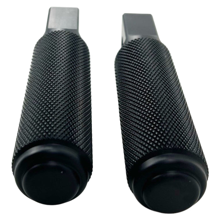 Two black, cylindrical, textured CNC machined aluminum foot pegs with mounting holes. -> Two black, cylindrical, textured CNC machined aluminum TC Bros. Nomad Passenger Foot Pegs fits 2018-up Harley Softail M8 & Pan America - Black from TC Bros.