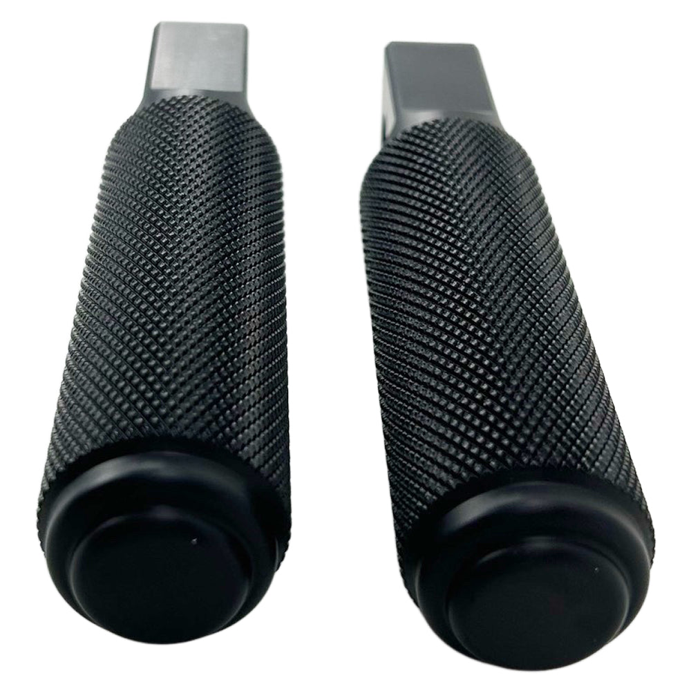 Two black, cylindrical, textured CNC machined aluminum foot pegs with mounting holes. -> Two black, cylindrical, textured CNC machined aluminum TC Bros. Nomad Passenger Foot Pegs fits 2018-up Harley Softail M8 & Pan America - Black from TC Bros.
