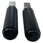 Two black, cylindrical, textured CNC machined aluminum foot pegs with mounting holes. -> Two black, cylindrical, textured CNC machined aluminum TC Bros. Nomad Passenger Foot Pegs fits 2018-up Harley Softail M8 & Pan America - Black from TC Bros.