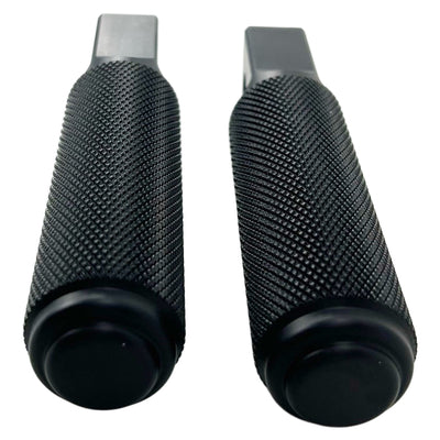 Two black, cylindrical, textured CNC machined aluminum foot pegs with mounting holes. -> Two black, cylindrical, textured CNC machined aluminum TC Bros. Nomad Passenger Foot Pegs fits 2018-up Harley Softail M8 & Pan America - Black from TC Bros.