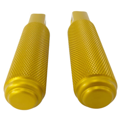 Two gold-tone metal cylindrical objects with textured grips, featuring a hole through their flat end pieces, arranged in a straight line. Crafted from CNC machined aluminum, these resemble TC Bros Nomad Passenger Foot Pegs fits 2018-up Harley Softail M8 & Pan America - Gold.