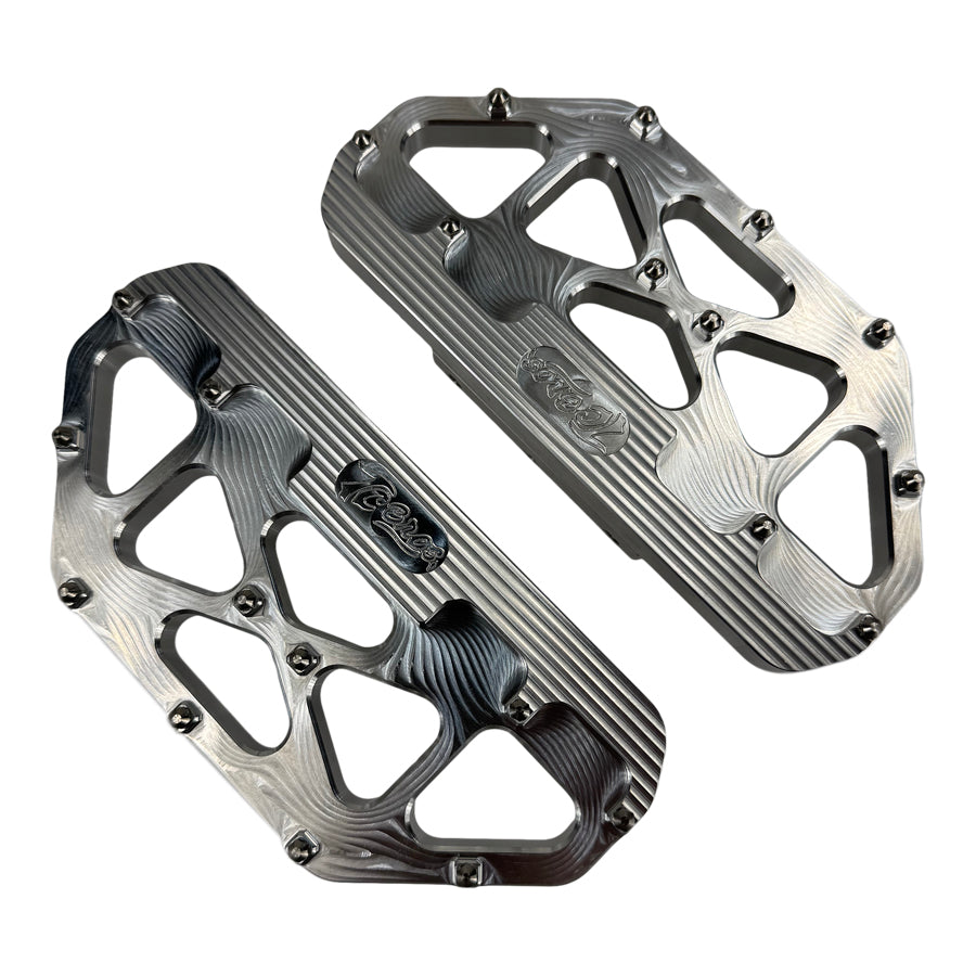 Three TC Bros. Pro Series MX Passenger Floorboards in black, silver, and gold are displayed on a white background, highlighting their design and color variations—perfect for Harley Davidson Bagger Touring enthusiasts seeking style and functionality.