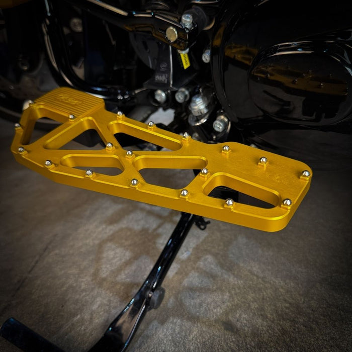 TC Bros. Pro Series MX Slim Floorboards for Harley Davidson Bagger Touring Models feature a skeletal design with metal pins, resembling high-performance pedals in silver, black, and gold. Arranged diagonally, they offer a striking visual appeal.